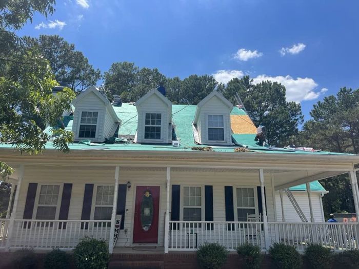 New underlayment going on a farmhouse with a wraparound porch